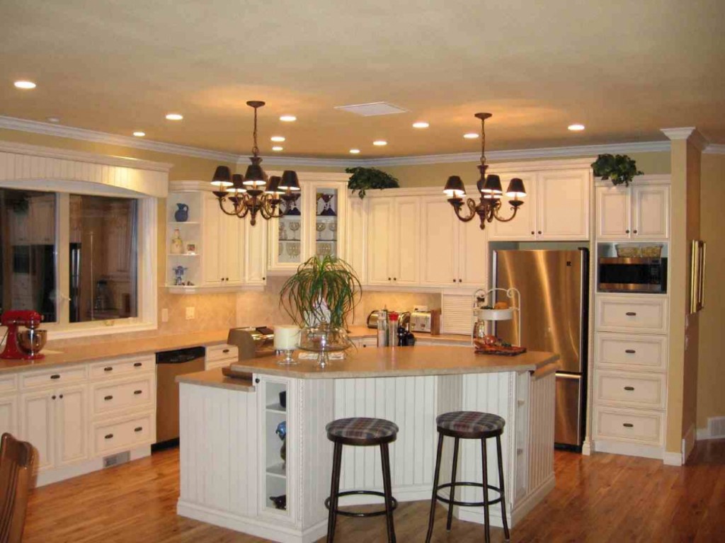 eleagnt and small U Shaped Kitchen Design Ideas with white apliances and curve island with black cahir and chandlier