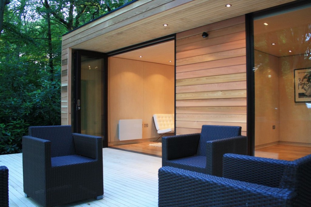 Contemporary home with frameless window with clean glass and outdoor lounge space with black sofa