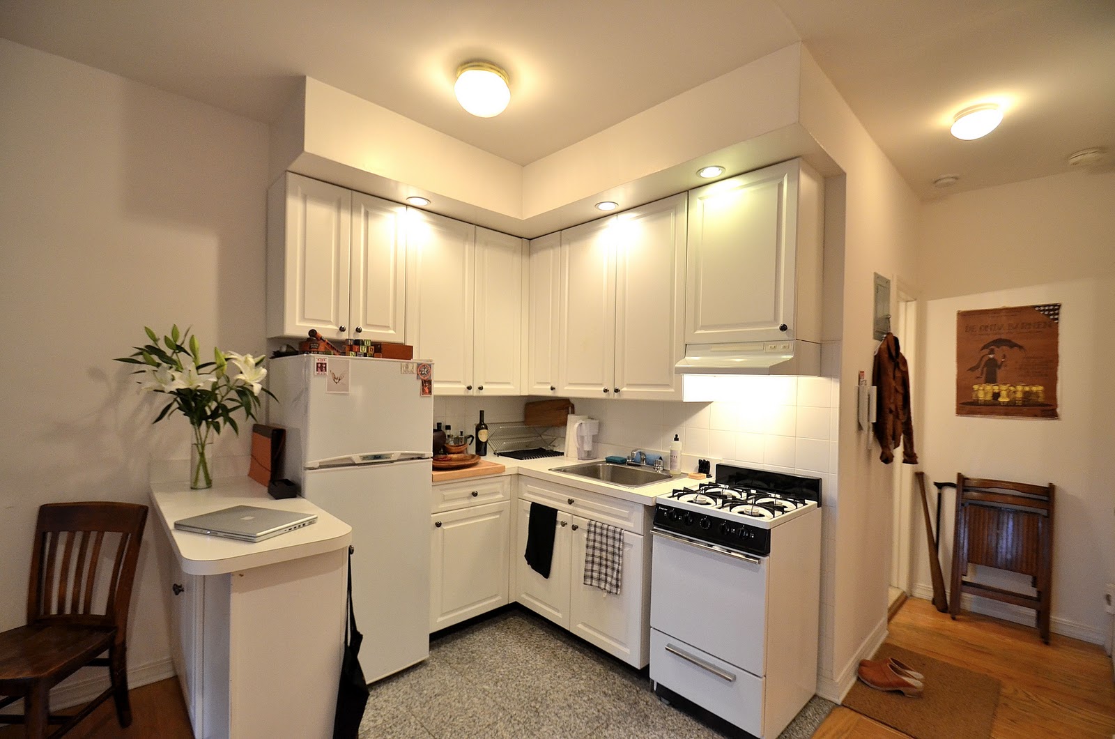 Small Kitchen New York Studio Apartment with white cabinet L shaped layout and fixture lighting