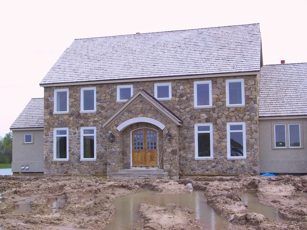 Pennsylvania Fieldstone with two floor in classic home with white window treatment and brown with glass door