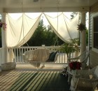 Covered Porch Decorating Ideas with hanging chair white curtain and wooden floor