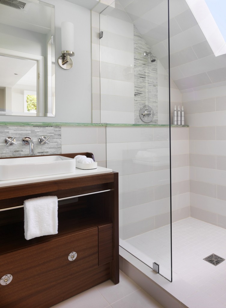 Frameless Shower Door Marin Glass and Windows in small bathroom with brown vanity and towel hanger and unique shape rooftop